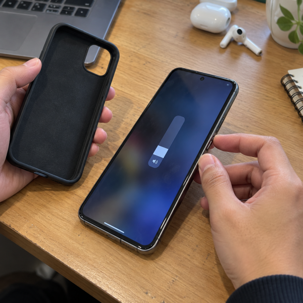 Pengguna melepas casing dan memeriksa tombol volume HP saat indikator suara terlihat menurun.